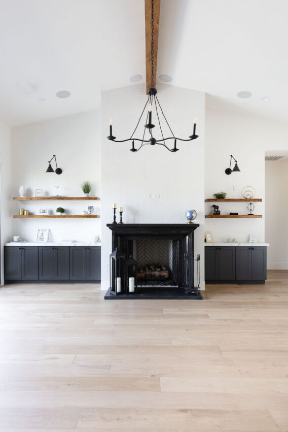 black-fireplace-chandelier-wood-beam-living-room